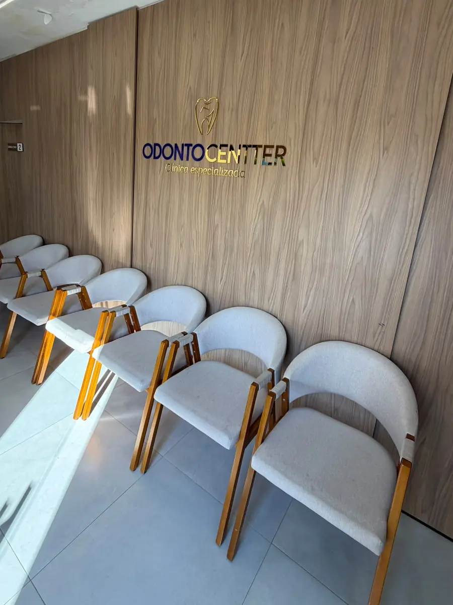Sala de espera da Odonto Centter, com a marca na parede de madeira
