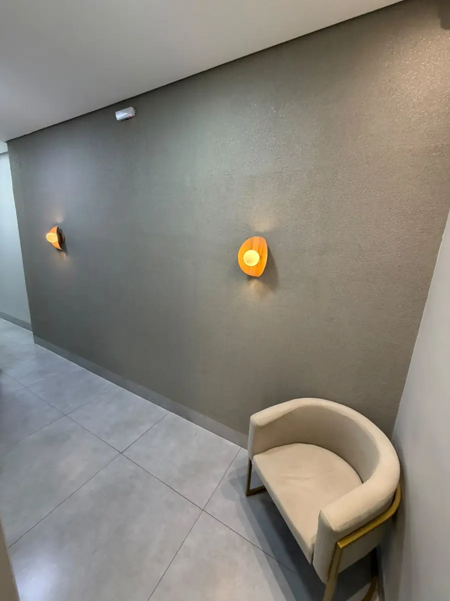 Canto de espera da Odonto Centter, com poltrona e iluminação indireta