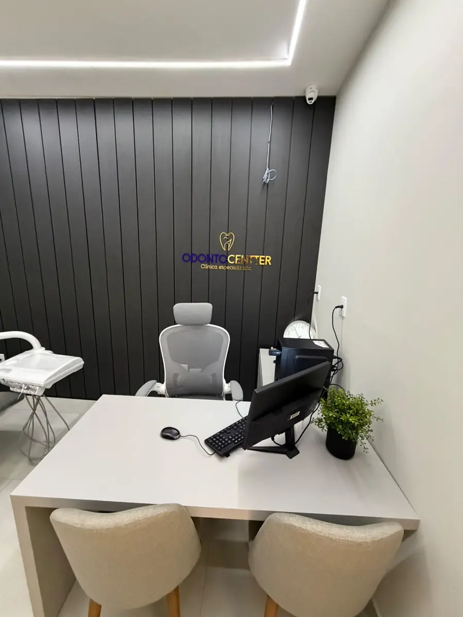 Consultório da Odonto Centter com painel escuro e a marca na parede