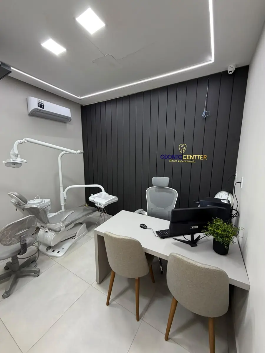 Consultório amplo da Odonto Centter, com cadeira odontológica e mesa para a consulta
