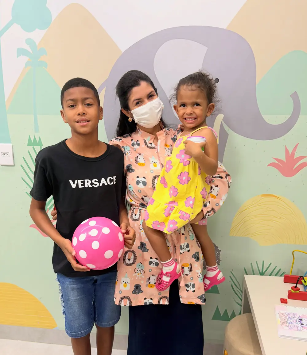 Profissional da Odonto Centter com dois irmãos após a consulta infantil