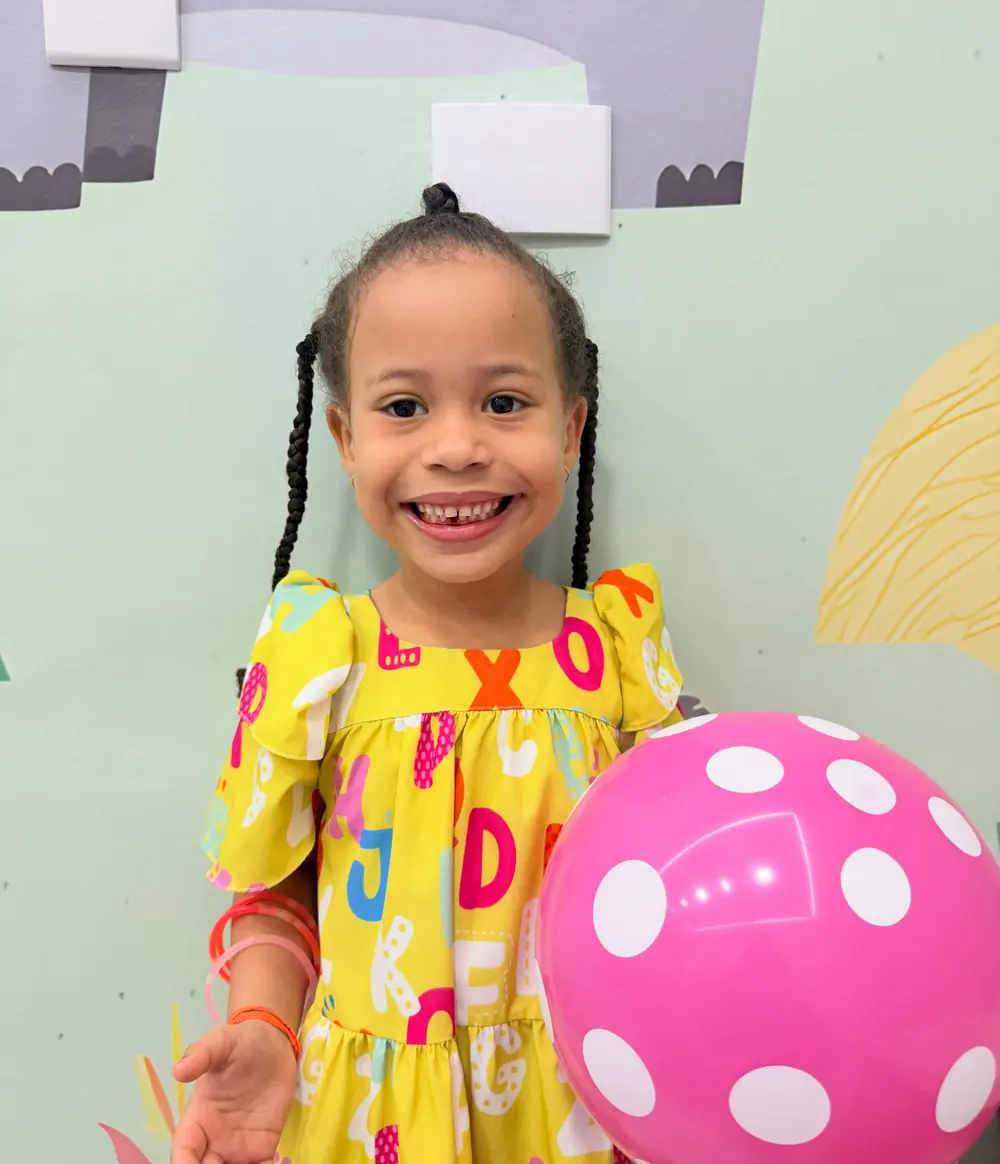 Menina sorridente com a bola que ganhou após a consulta na Odonto Centter